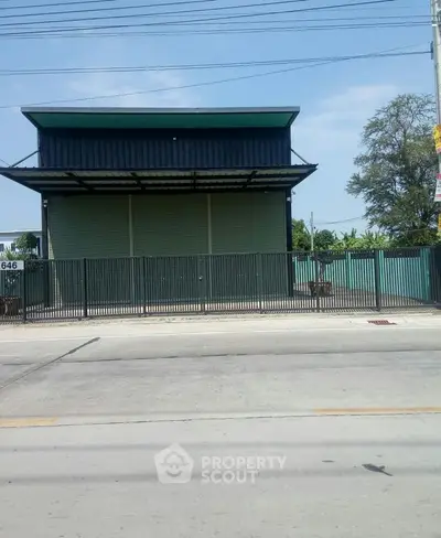 Modern industrial building with secure gated entrance and spacious exterior.