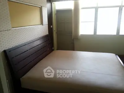 Spacious bedroom with large window and modern bed frame