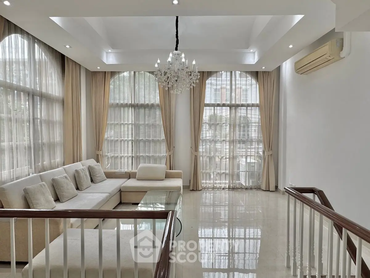 Luxurious living room with elegant chandelier and large windows