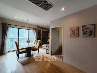 Spacious dining area with large windows and elegant decor in modern apartment.