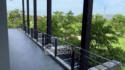 Spacious balcony with lush green views and modern railing design.