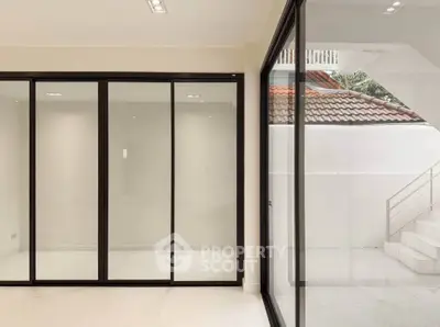 Spacious modern room with large glass doors and outdoor view, perfect for natural light.