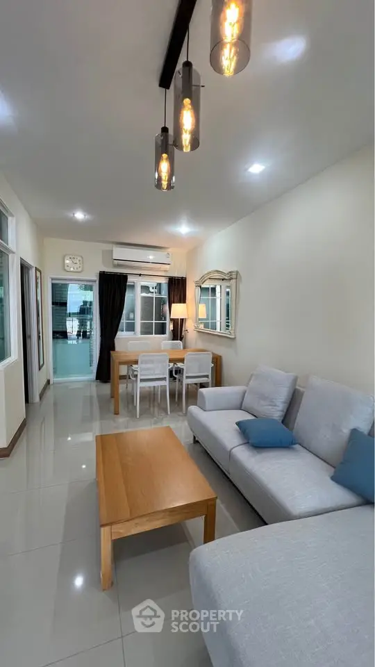 Spacious living room with modern decor and elegant lighting, perfect for family gatherings.