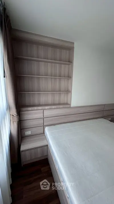 Modern bedroom with built-in wooden shelves and large window for natural light.