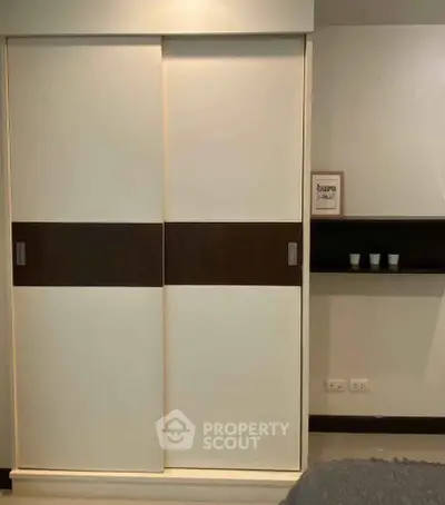 Modern bedroom with sleek sliding closet doors and minimalist decor.