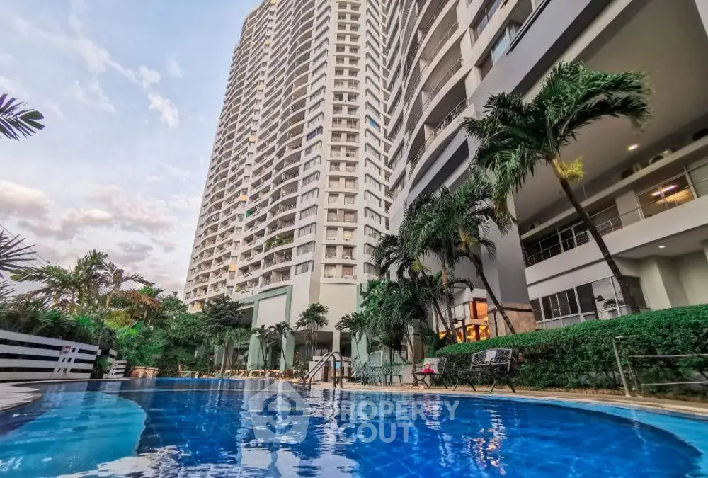 Luxurious high-rise building with inviting pool and lush greenery, perfect for modern living.