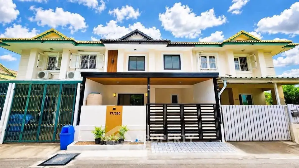 Charming townhouse with modern facade and gated entrance in a serene neighborhood.