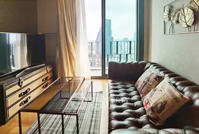 Stylish living room with leather sofa and city view balcony in modern apartment