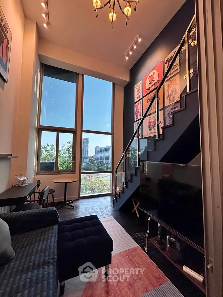 Stunning loft-style living room with high ceilings and large windows offering a breathtaking city view.