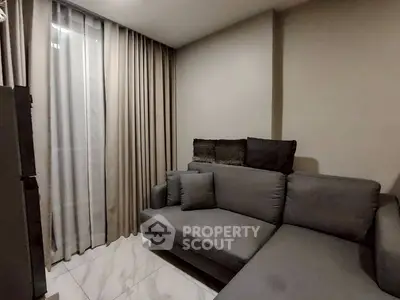 Cozy living room with modern gray sofa and elegant curtains