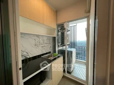 Modern compact kitchen with sleek design and balcony view, featuring marble backsplash and wooden cabinets.