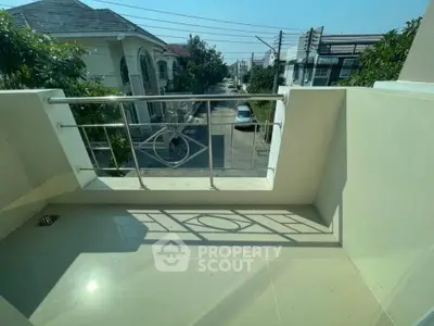 Charming small balcony with street view in a suburban neighborhood, perfect for morning coffee.