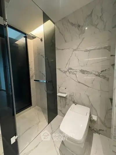 Luxurious modern bathroom with marble tiles and sleek fixtures in upscale property.