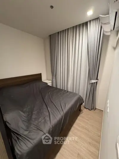 Cozy bedroom with modern decor and elegant curtains, perfect for restful nights.