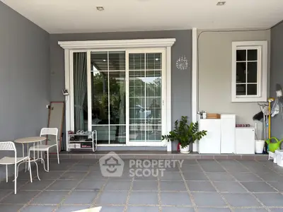Charming patio with sliding glass doors and cozy outdoor seating area.
