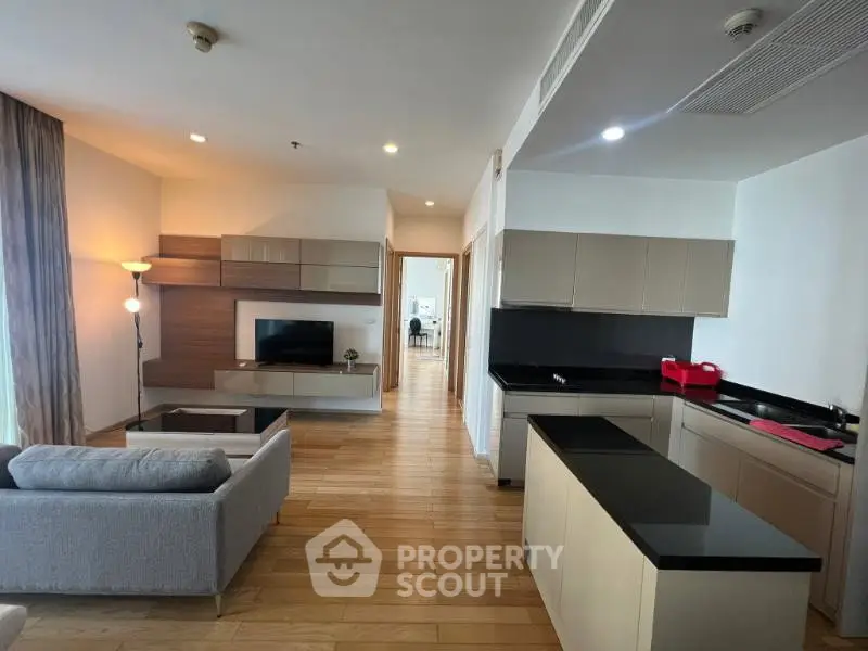 Spacious modern living room with open kitchen and sleek wooden flooring