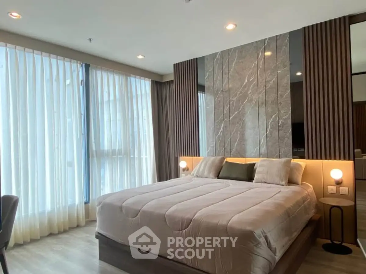 Luxurious modern bedroom with elegant decor and large windows for natural light.