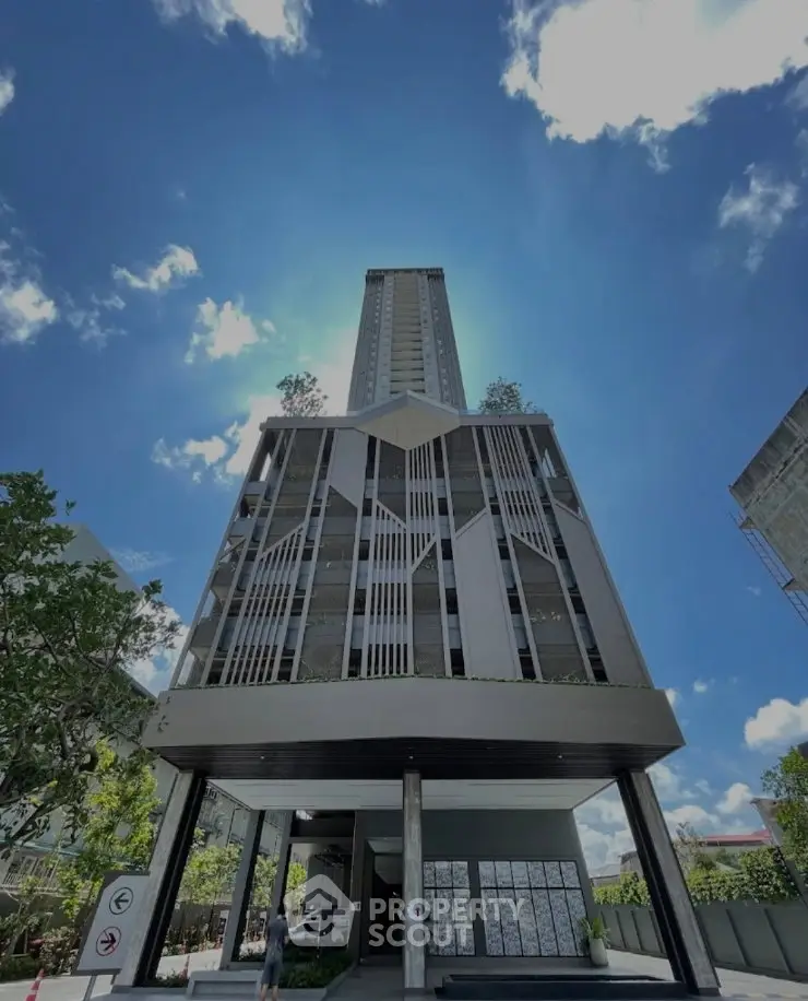Stunning modern high-rise building with unique architectural design under a clear blue sky.