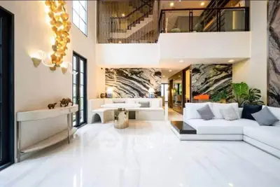 Luxurious modern living room with high ceilings and elegant marble accents.