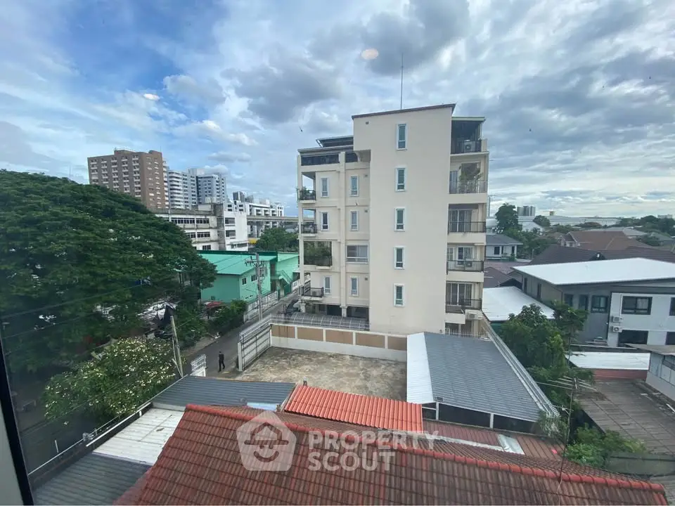 Stunning urban view from a high-rise building showcasing cityscape and greenery.