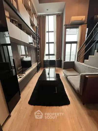 Modern loft-style living room with high ceilings and large windows