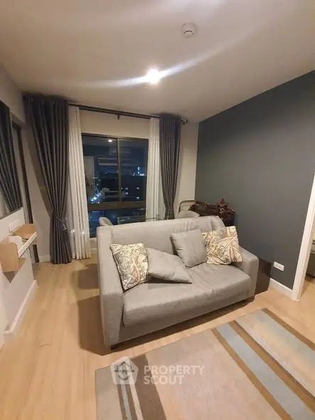 Modern living room with cozy sofa and large window offering city view
