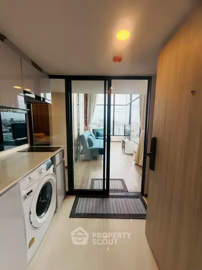 Modern apartment entrance with washing machine and spacious living area view.