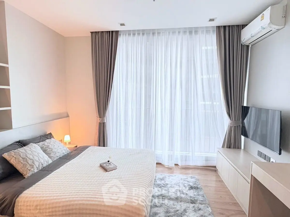 Modern bedroom with large window, stylish decor, and cozy ambiance