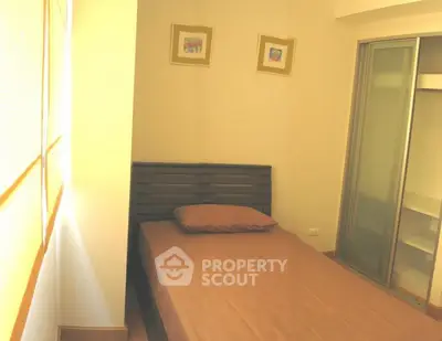 Cozy small bedroom with single bed and sliding closet doors.