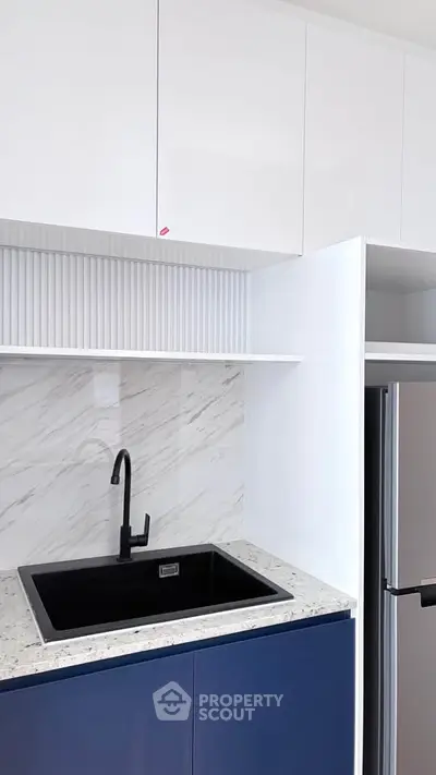 Modern kitchen with sleek black sink and marble backsplash
