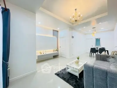 Elegant living room with chandelier and modern dining area in open layout