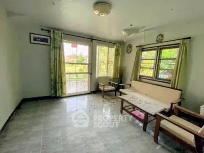 Spacious living room with natural light and garden view, featuring cozy seating and elegant decor.