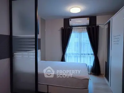 Modern bedroom with large window and stylish decor in a contemporary apartment.