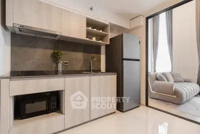 Modern kitchen with sleek appliances and open layout adjacent to cozy living room.