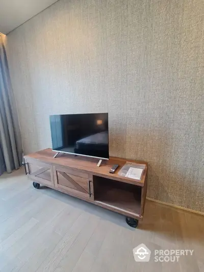 Modern living room with stylish wooden TV stand and flat-screen television.