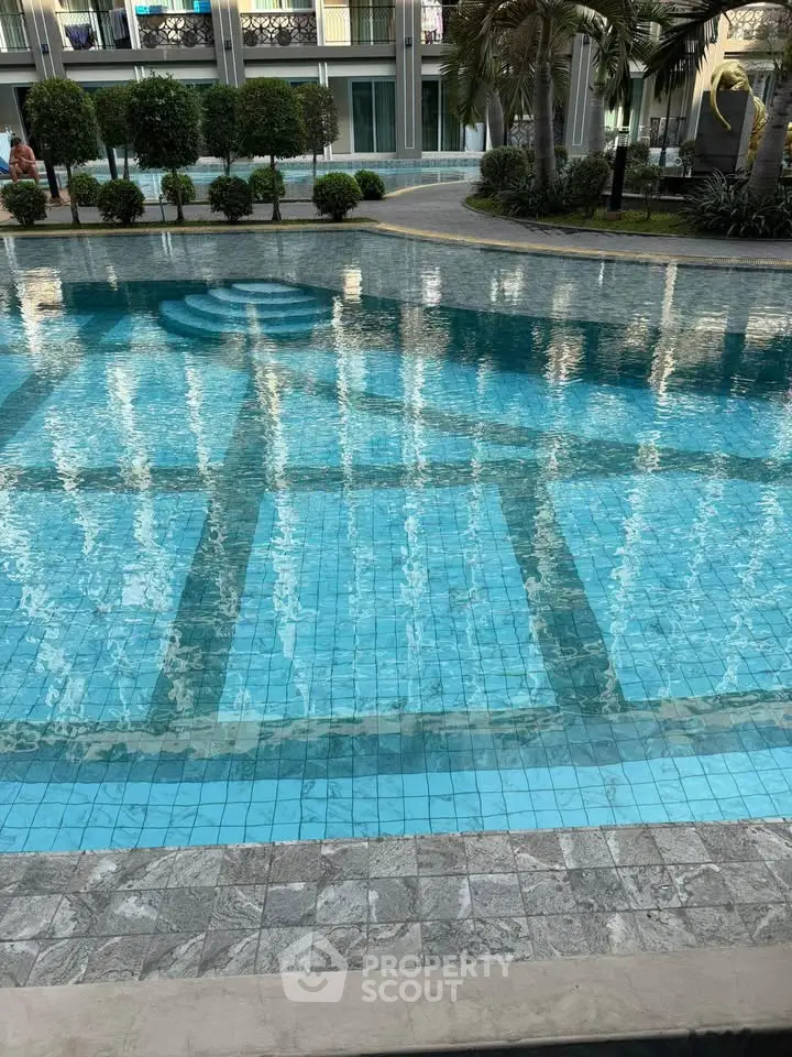 Luxurious swimming pool with clear blue water and elegant surroundings in a modern residential complex.