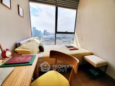 Cozy bedroom with city view, featuring a study desk and modern decor, perfect for urban living.