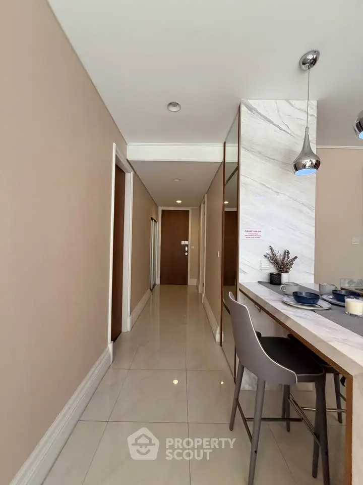 Modern apartment hallway with stylish dining area and pendant lighting
