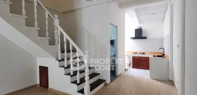 Charming interior with staircase and modern kitchen in open layout design.