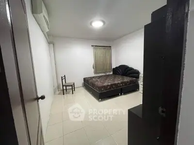 Spacious bedroom with minimalist decor and large bed in modern apartment.