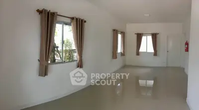 Spacious empty room with large windows and elegant curtains, perfect for customization.