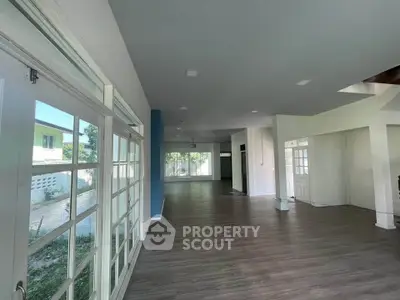 Spacious open-plan living area with large windows and modern flooring