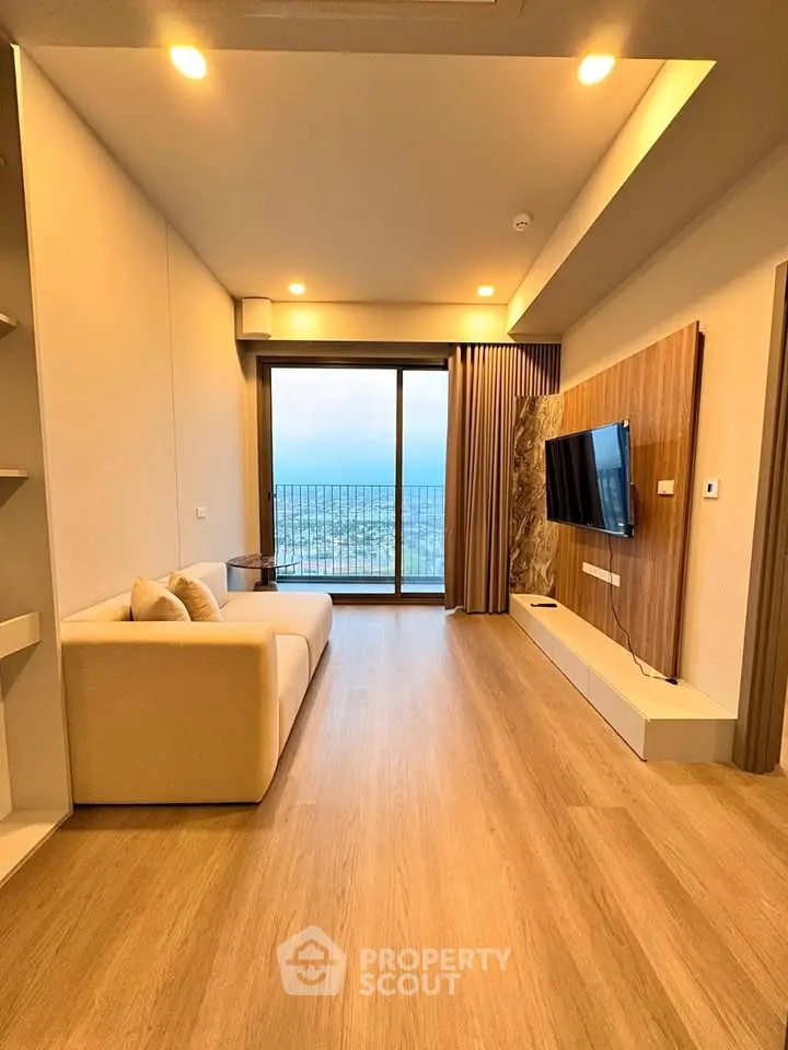 Modern living room with ocean view, featuring sleek design and large windows for natural light.