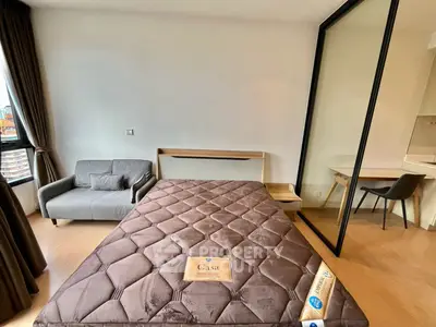 Modern bedroom with stylish furniture and large window offering city views, perfect for urban living.