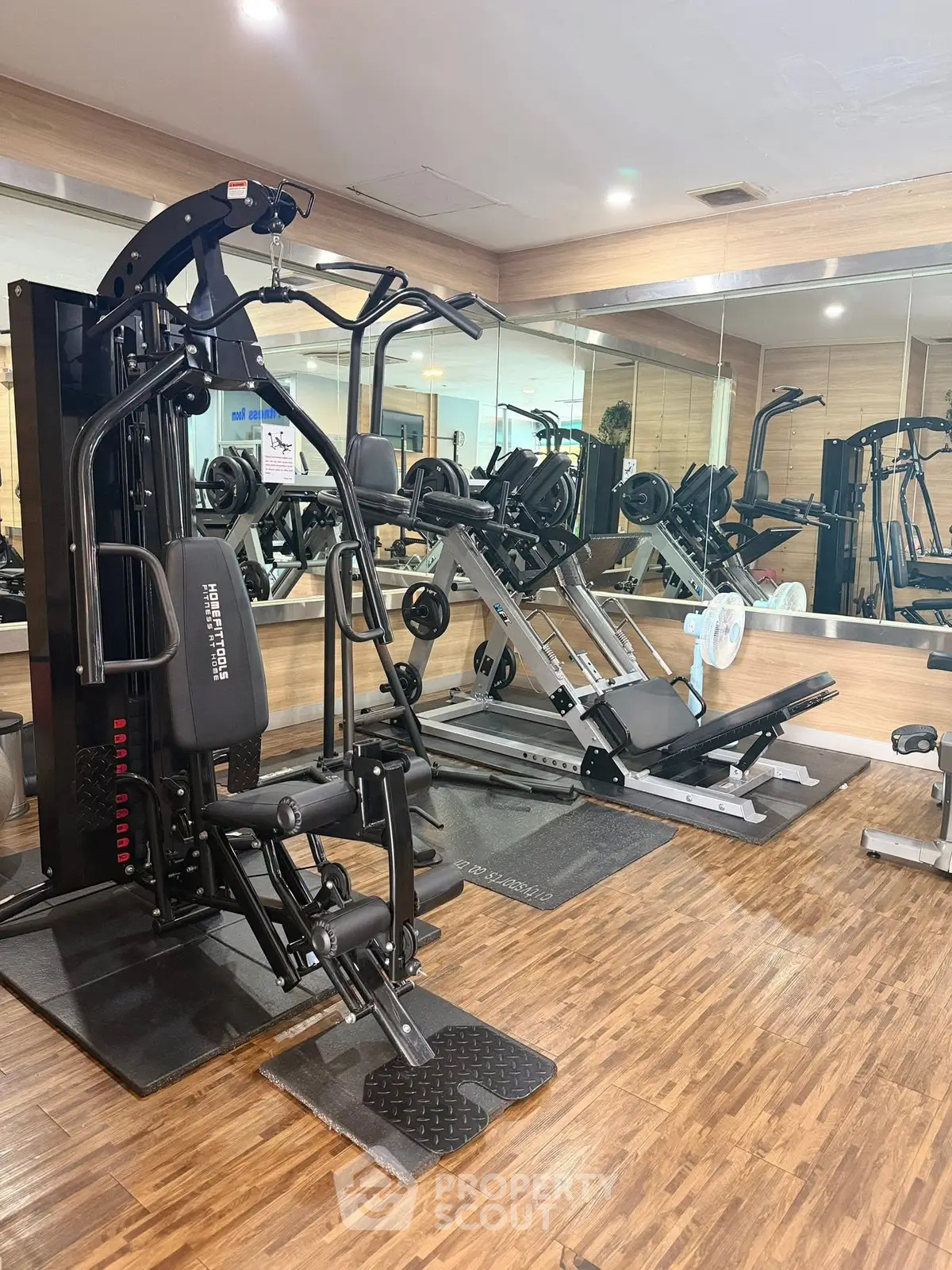 Modern gym with state-of-the-art fitness equipment and mirrored walls in a residential building.