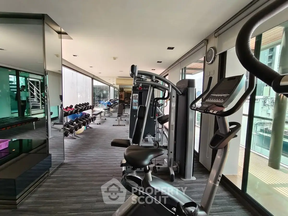 Modern gym with state-of-the-art equipment and floor-to-ceiling windows for natural light.