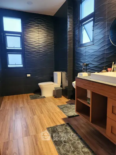 Luxurious modern bathroom with textured walls and wooden flooring