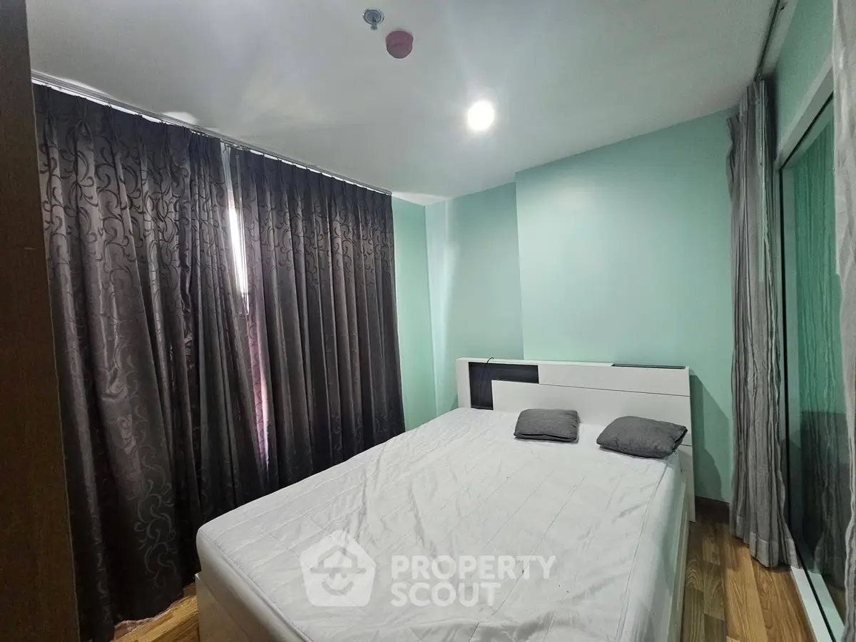Cozy bedroom with modern decor and ample natural light, featuring a comfortable bed and elegant curtains.
