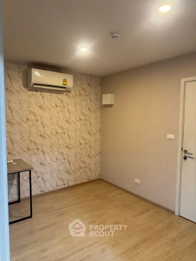 Modern empty room with air conditioning and stylish wallpaper, perfect for a home office or study.