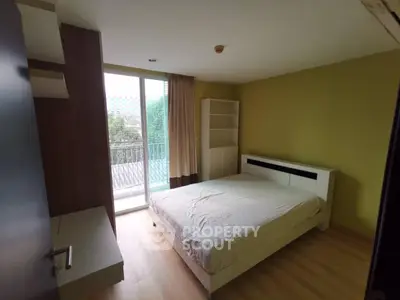 Spacious bedroom with balcony access and natural light in modern apartment.